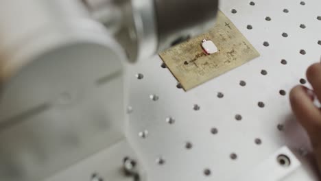 close up of busy biracial female worker using machine for scanning jewellery in slow motion