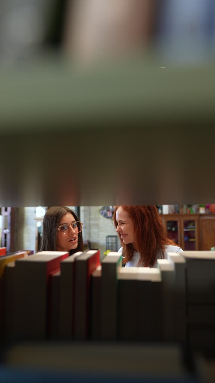 Two Friends Talking in a Library