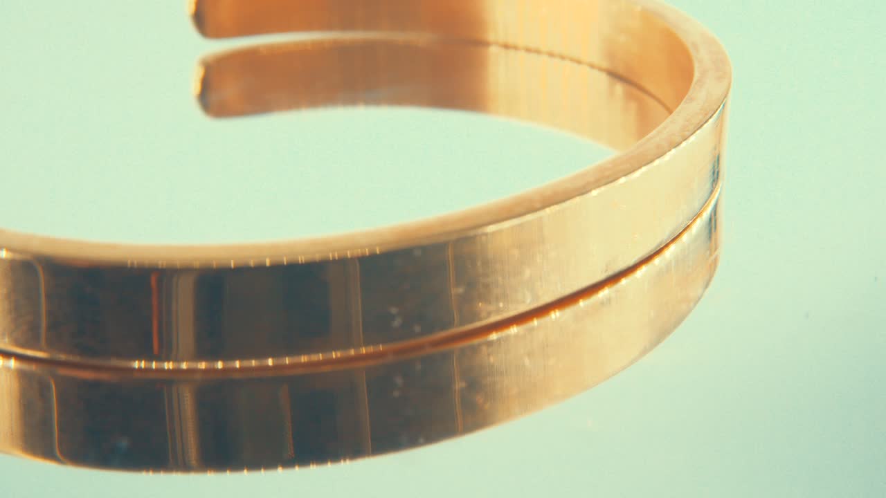 360 스탠드, 4k에 있는 금팔찌의 매크로 회전 클로즈업 샷