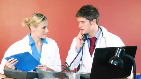 Médicos-Trabajando-En-El-Consultorio-Y-Hablando-Por-Teléfono