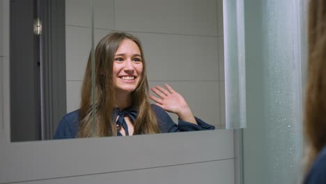 Happy-young-woman-showing-joy-emotion-against-mirror