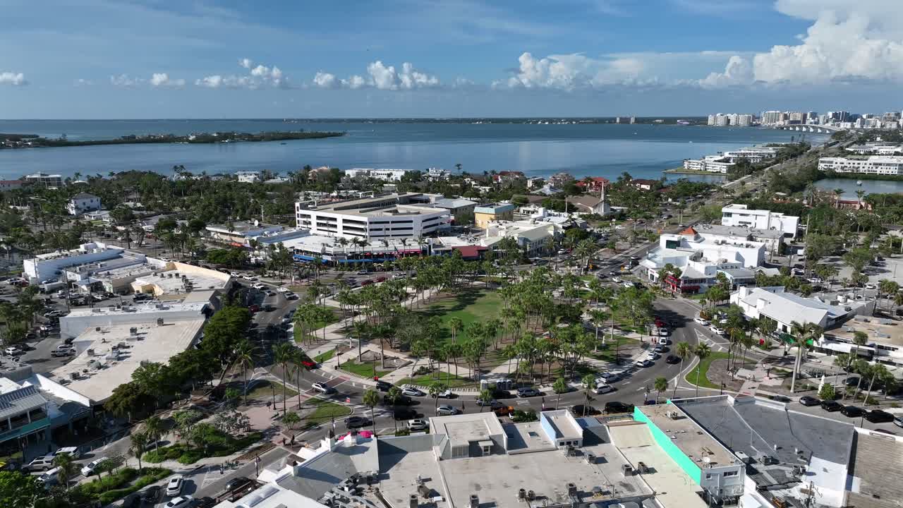 Aerial view of Sarasota, Florida’s St. Armands Circle. Lush green park, coastal skyline and vibrant shops with charm of this iconic Gulf Coast destination in the USA. Wide shot. Sunny summer day.
