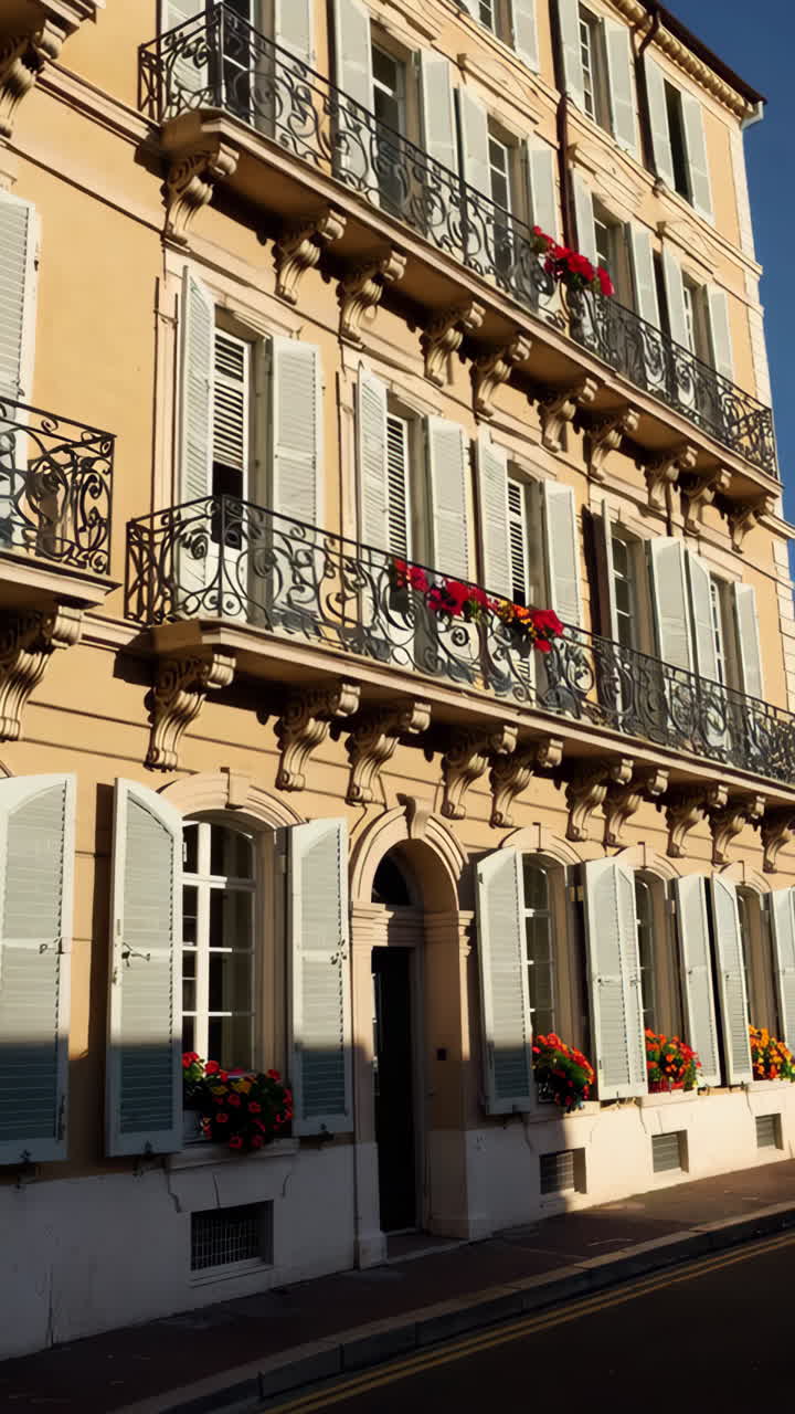 Elegant Building Facade with Ornate Balconies and Red Flowers