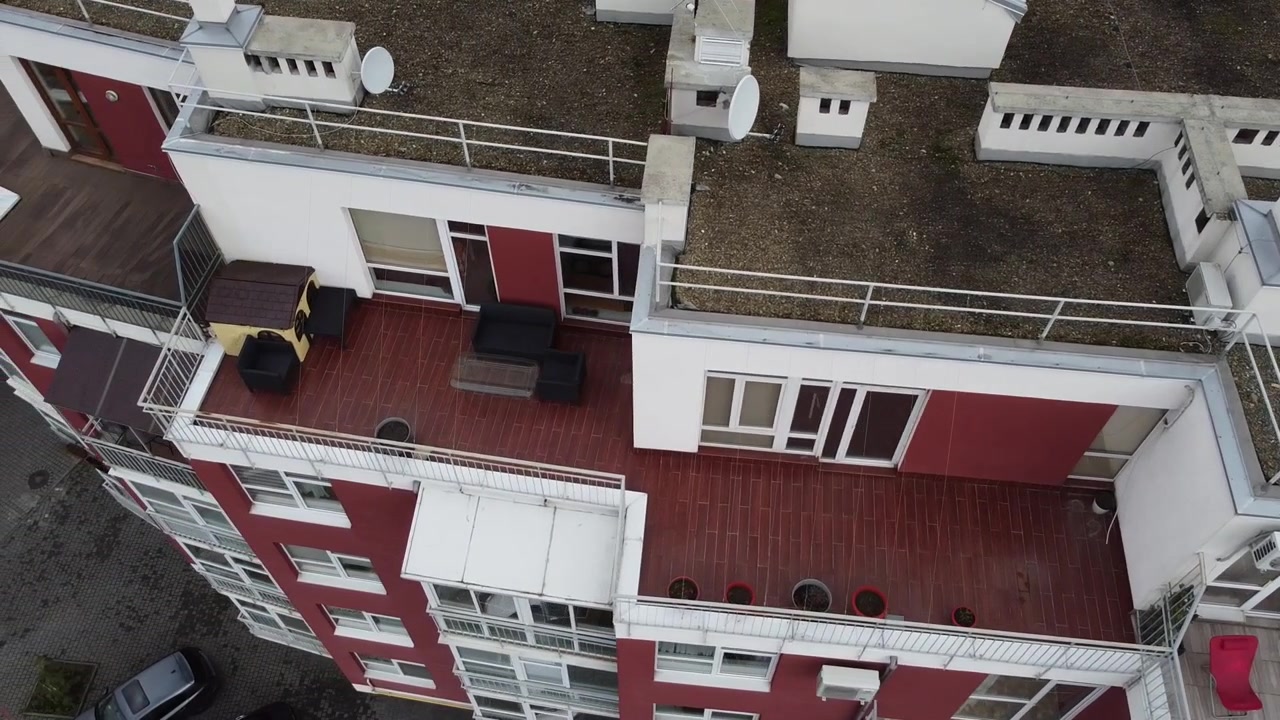 Luftfoto af en drone, der flyver over boligbygninger, med optagelser af tage og arkitektur.