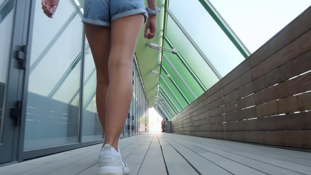 Una giovane donna che passeggia lungo un'elegante passerella coperta