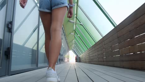 a young woman walking down a trendy covered boardwalk