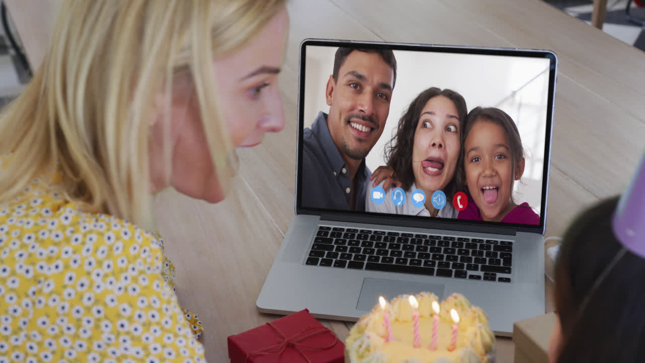 madre y hija caucásicas celebrando su cumpleaños haciendo una videollamada en una computadora portátil en casa