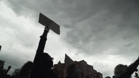 silueta blm london manifestante sostiene un cartel