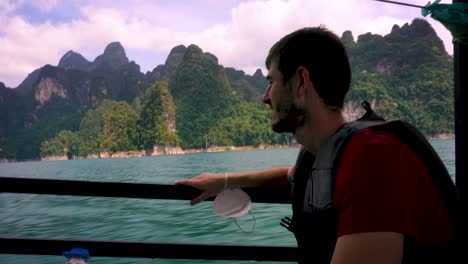 a side view of a young man wearing life jacket on sea vacation on a boat tour