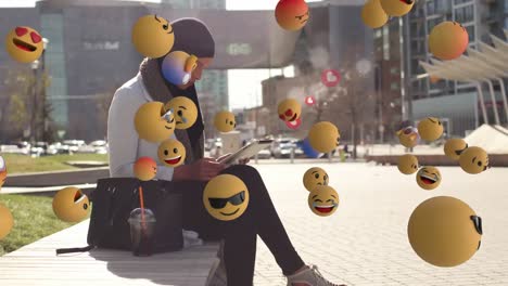 mujer árabe usando tableta en la calle con emoticones agitando