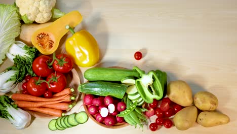 hand rearranging fresh vegetables on wooden surface