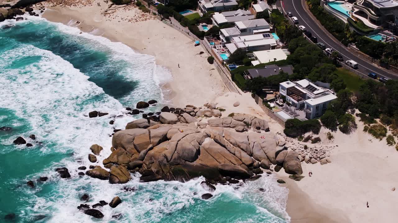 남아프리카 공화국 케이프타운의 캠프 베이 비치와 글렌 비치를 분리하는 그라나이트 바위 위에서 드론이 니다.