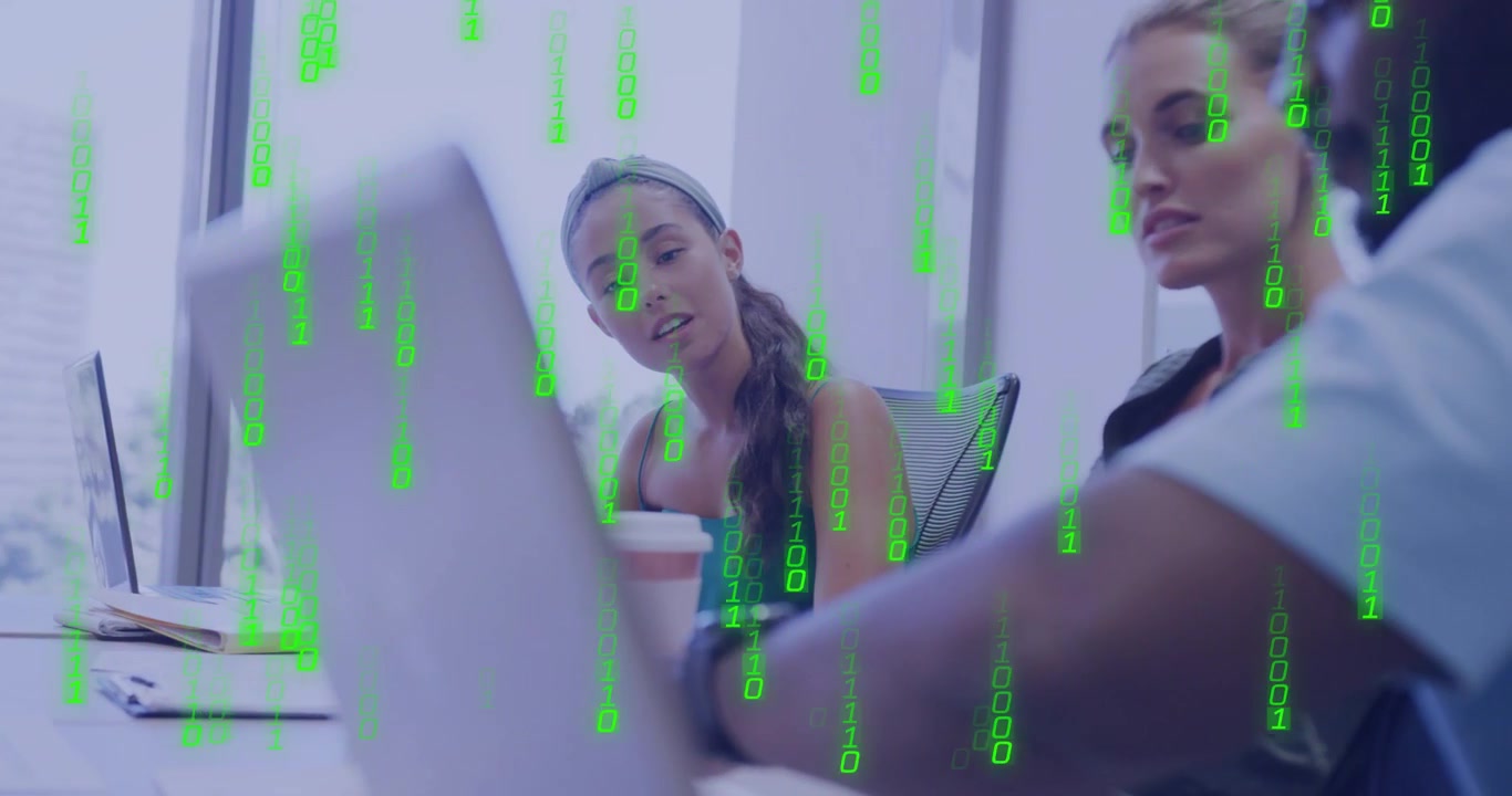 Uomo che si avvicina al laptop e guida il team in una riunione tecnica, controllando i dati mentre un codice verde si sovrappone al team.
