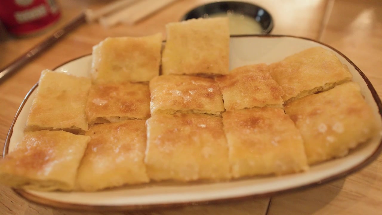 Primo piano di quadrati di roti fritti dorati su un piatto a Bangkok, Thailandia