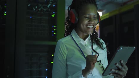 african american female computer technician using tablet working in business server room