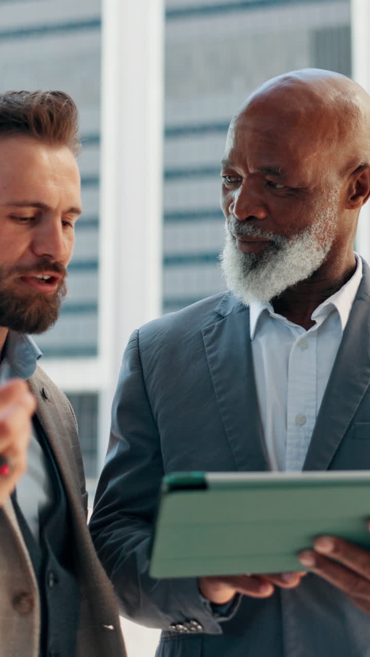 Two Diverse Businessmen Discussing Data on a Tablet Outdoors