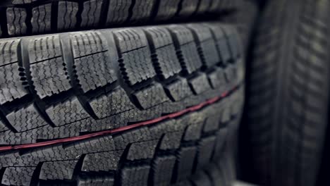 many new winter tires on shelves and in columns. panorama of the store.