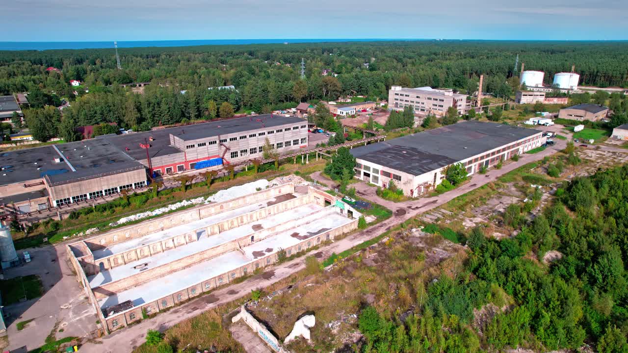 Aerial view of an abandoned industrial area in Latvia surrounded by trees