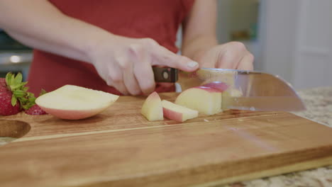 mujer cortando una manzana fresca en una tabla de cortar