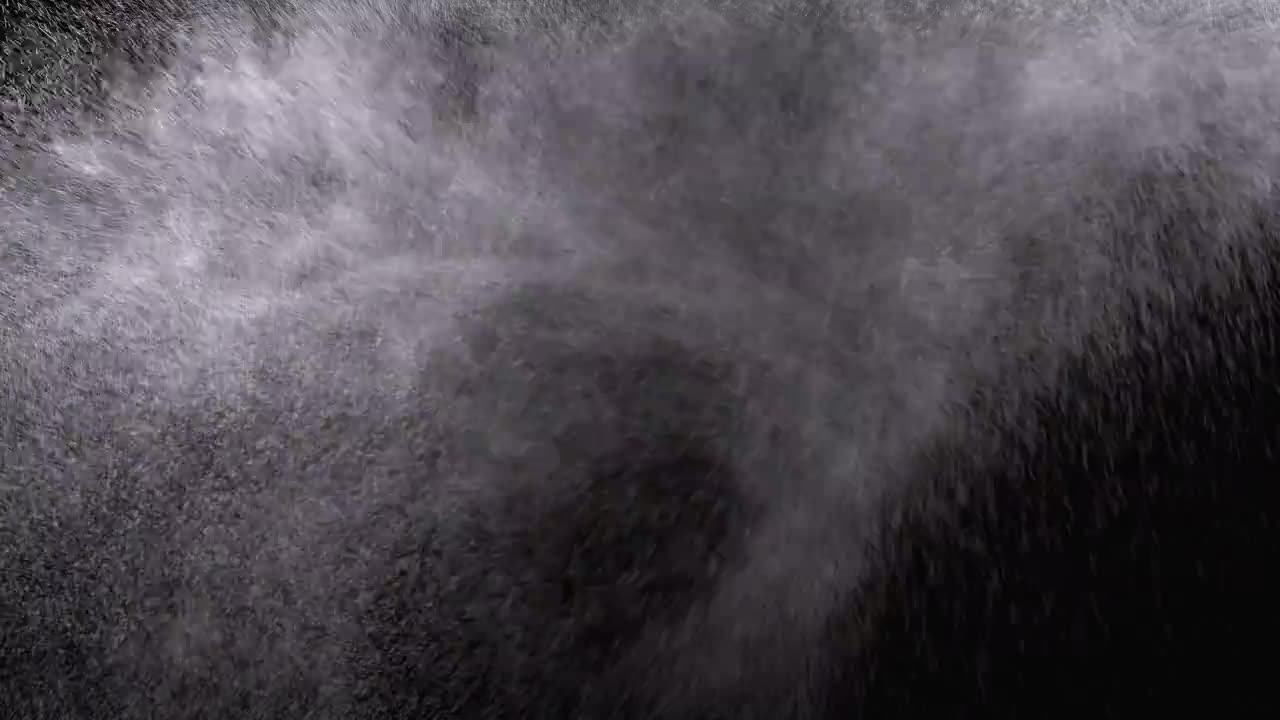 Spruzzo d'acqua su sfondo nero. Microgocce d'acqua volano nell'aria. Movimento lento.