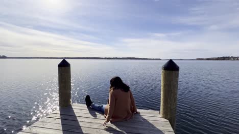 Girl-with-a-cute-autumn-outfit-seated-on-a-boat-launching-deck