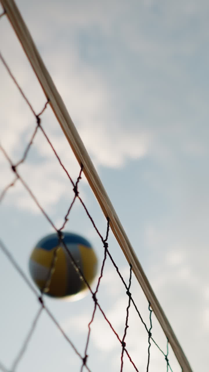 은 하늘과 밝은 빛으로 야외에서 볼리볼 경기를 하는 동안의 행동을 보여주는 공허 하늘 아래에서 볼이볼 망과 함께 볼이볼을 연주하는 클로즈업