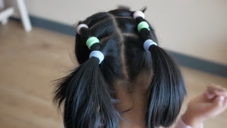 child with pigtails and colorful hair bands