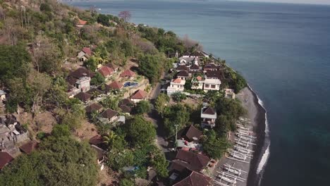 aerial view of a touristic village with small houses surrounded by turquoise seawater in indonesia