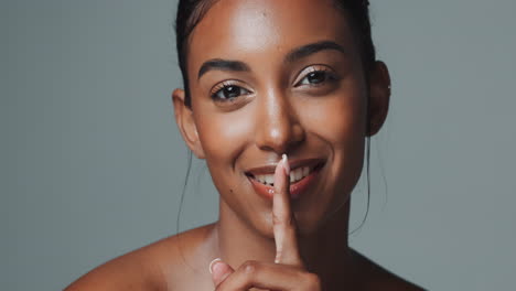 woman with finger to lips shushing