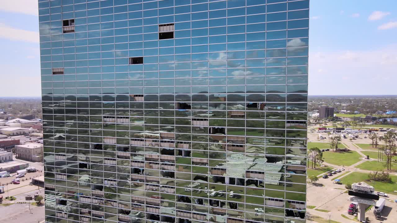 공중 드론 영상은 아이오와에서 폭풍, 강풍 피해, 깨진 창문이 있는 유리 고층 사무실 건물을 미러링했습니다.