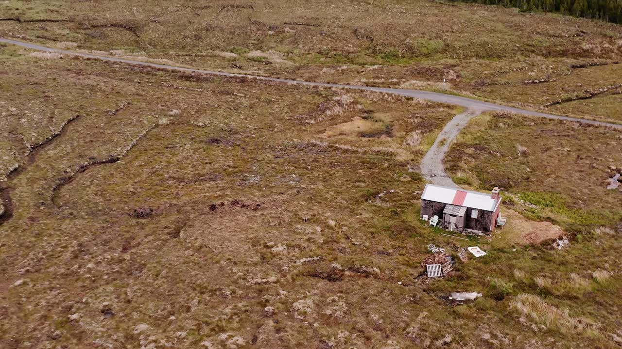 tomada de un dron de un moorland shieling y una granja eólica en la isla de lewis