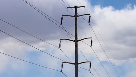 overhead high voltage transmission lines blowing in the wind as clouds rumble in the background in this 4k timelapse