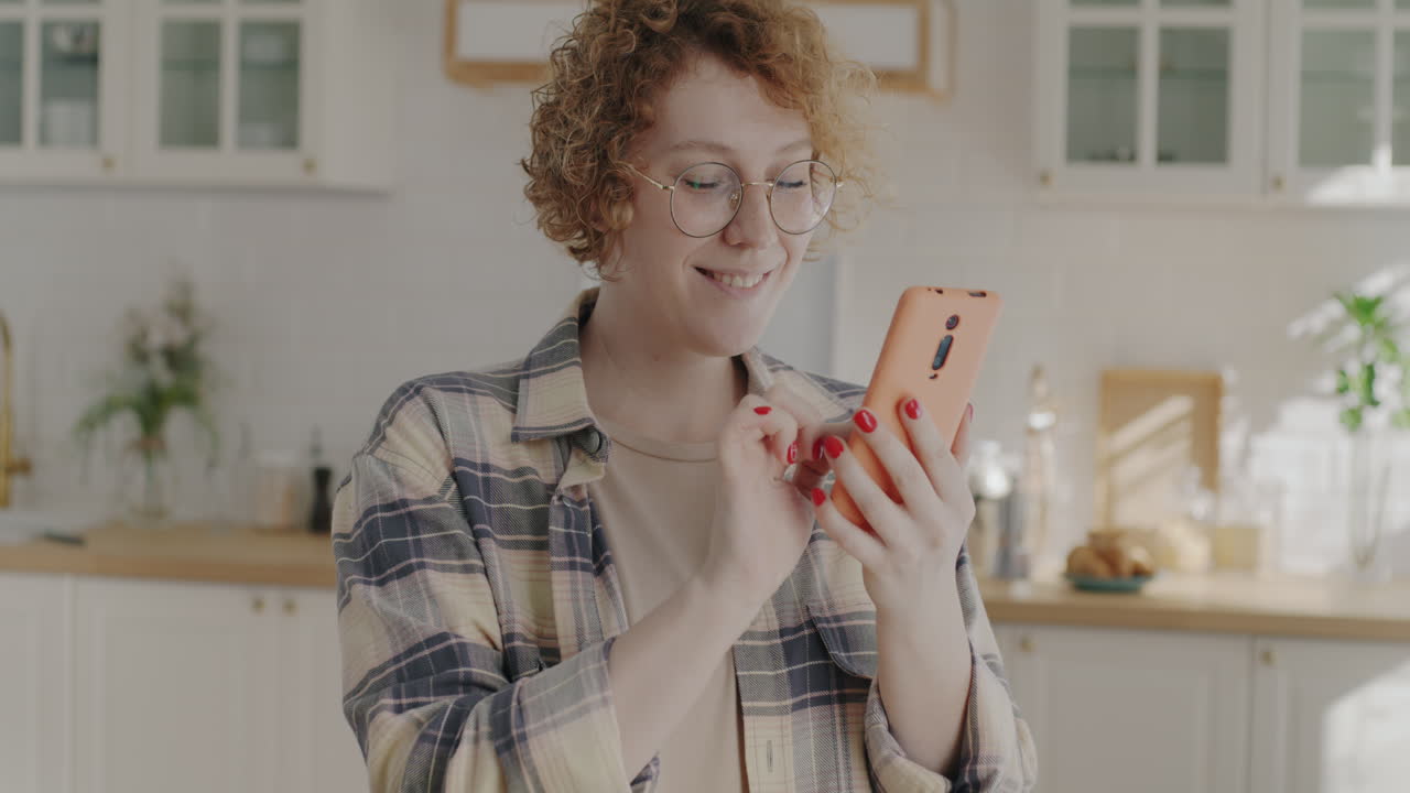mujer usando el teléfono en la cocina