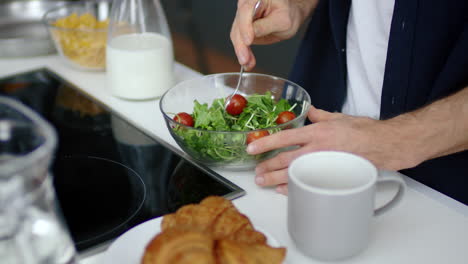 Closeup-hungry-man-eating-fresh-salad-at-home-kitchen-in-slow-motion.