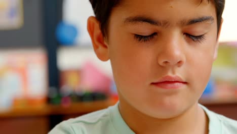 primer plano de un escolar caucásico sentado en el escritorio en el aula de la escuela 4k