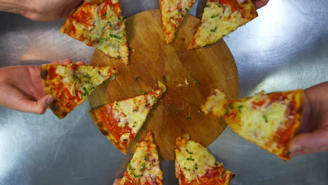 freshly prepared pizza on a stainless steel table in a cafe kitchen. appetizing hot pizza with cheese, bacon and greens on the top.