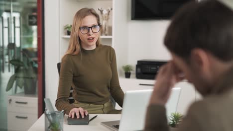 the young female boss sits in her office and talks to her subordinate. she is dissatisfied with his work, and the conversation between them is unpleasant. the female boss dismisses her worker