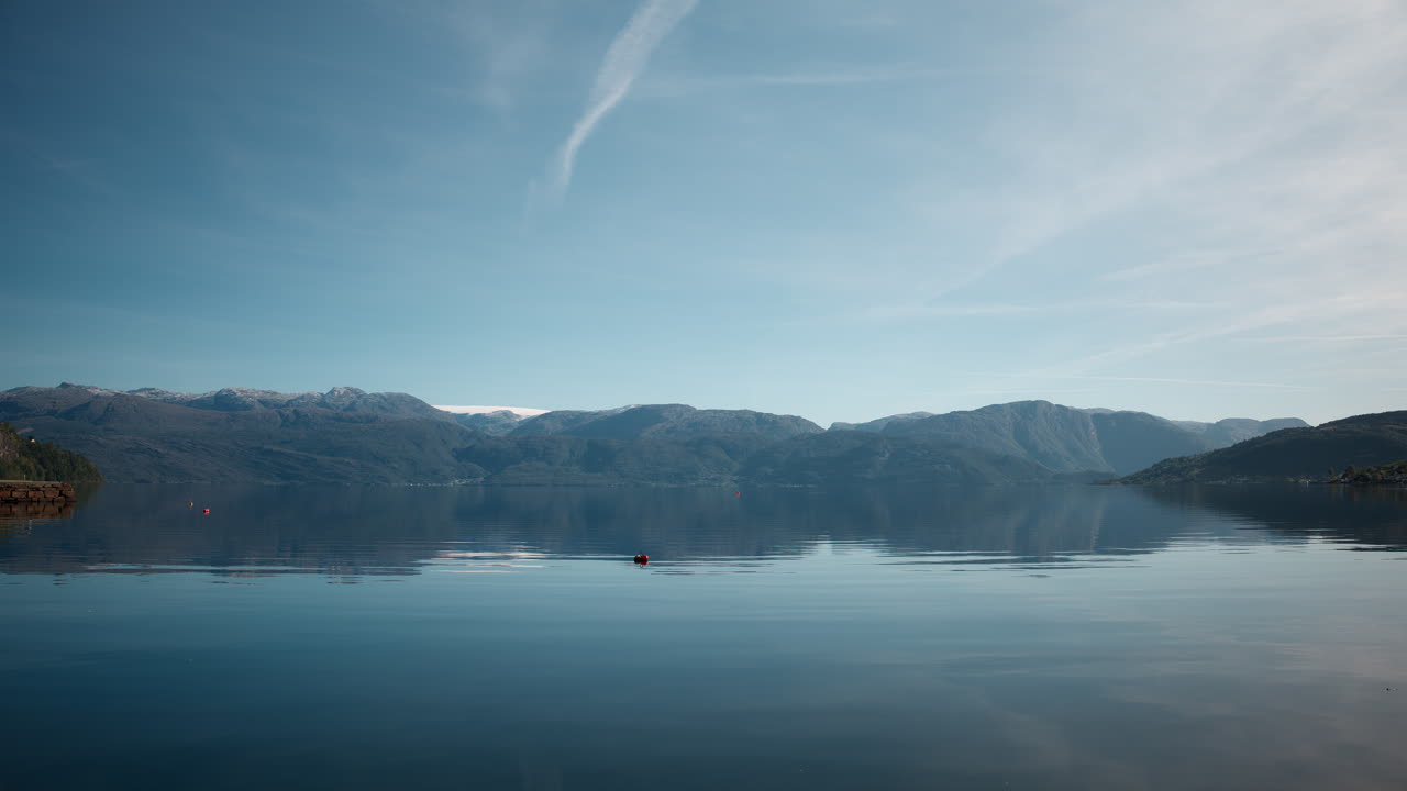 Scenic shot of the Hardangerfjord, Norway on a sunny day with calm water and clear reflection