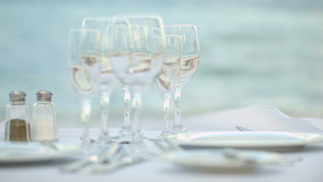 Served-table-with-empty-dishware-against-sea-background