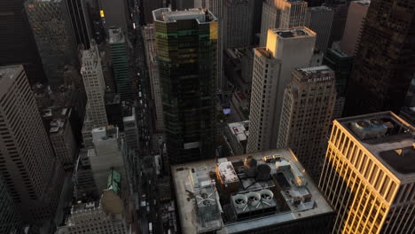 Aerial-view-of-high-rise-buildings-in-city.-Tilt-down-to-street-deep-between-skyscrapers.-Manhattan,-New-York-City,-USA