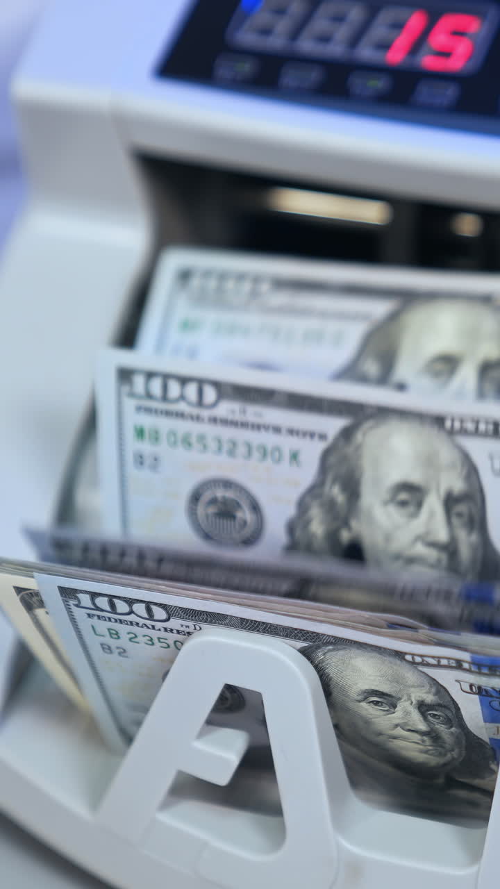 Money and business. Money counting on special machine. Banking modern counter with dollars concept. Cropped view. Vertical video