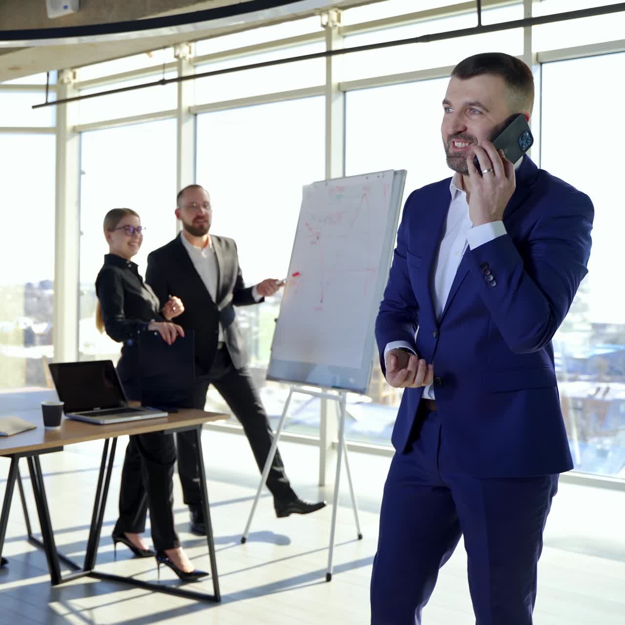 Persone d'affari in ufficio. Giovani imprenditori che lavorano a nuovi progetti. Uomo d'affari di successo in giacca e cravatta che parla al telefono