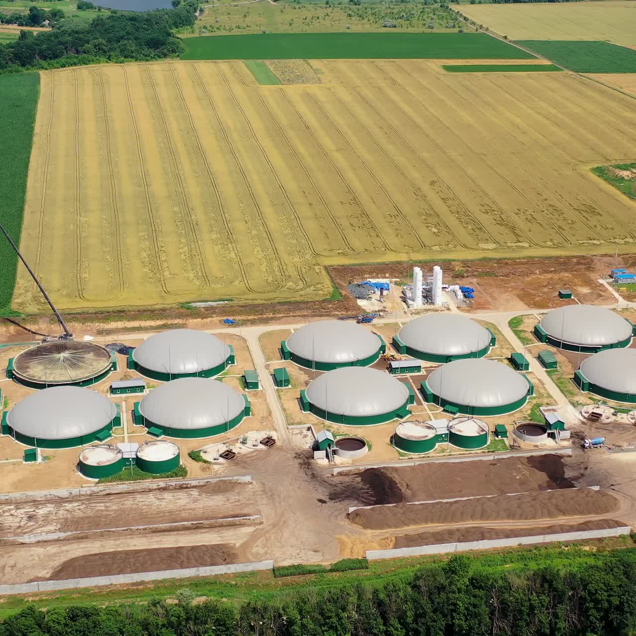 Biogas plants on field. Modern plant for renewable energy production from biomass. New agriculture factory. Aerial view