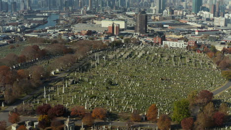 High-angle-view-of-old-Calvary-Cemetery.-Tilt-up-reveal-of-skyline-with-Manhattan-skyscrapers.-Queens,-New-York-City,-USA