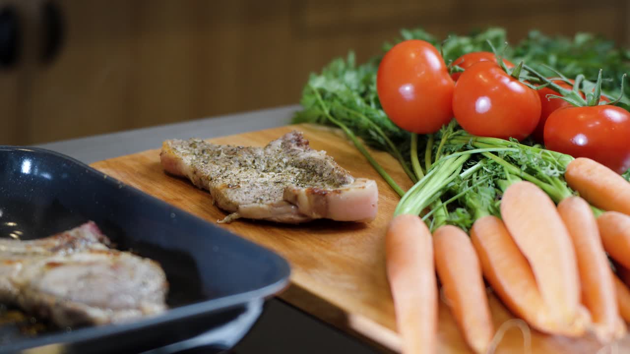 wooden spoon lifts seasoned pork chop beside vibrant raw vegetables