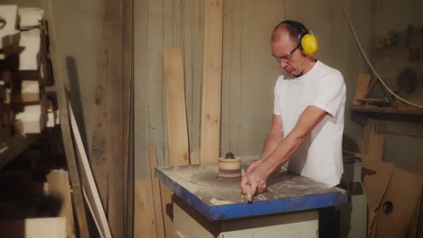 carpintero que lijaba madera en un taller
