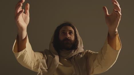 Portrait Of Man Wearing Robes With Long Hair And Beard Representing Figure Of Jesus Christ Raising Hands In Prayer 2
