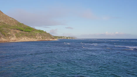 drone-footage-from-the-ocean-POV-of-the-waves-rolling-onto-the-sandy-shores-on-a-sunny-day-in-the-Hawaiin-islands-Oahu