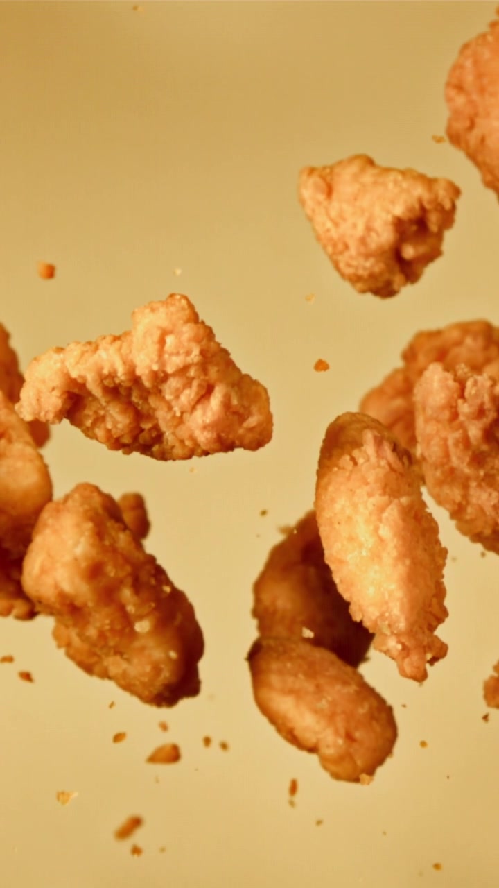Crocchette di pollo fritte croccanti che fluttuano al rallentatore