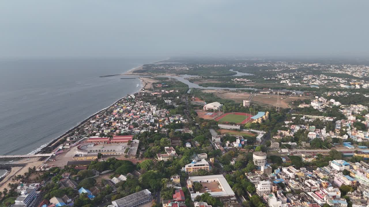 Calm ocean waves brushing against the city’s edge under soft daylight